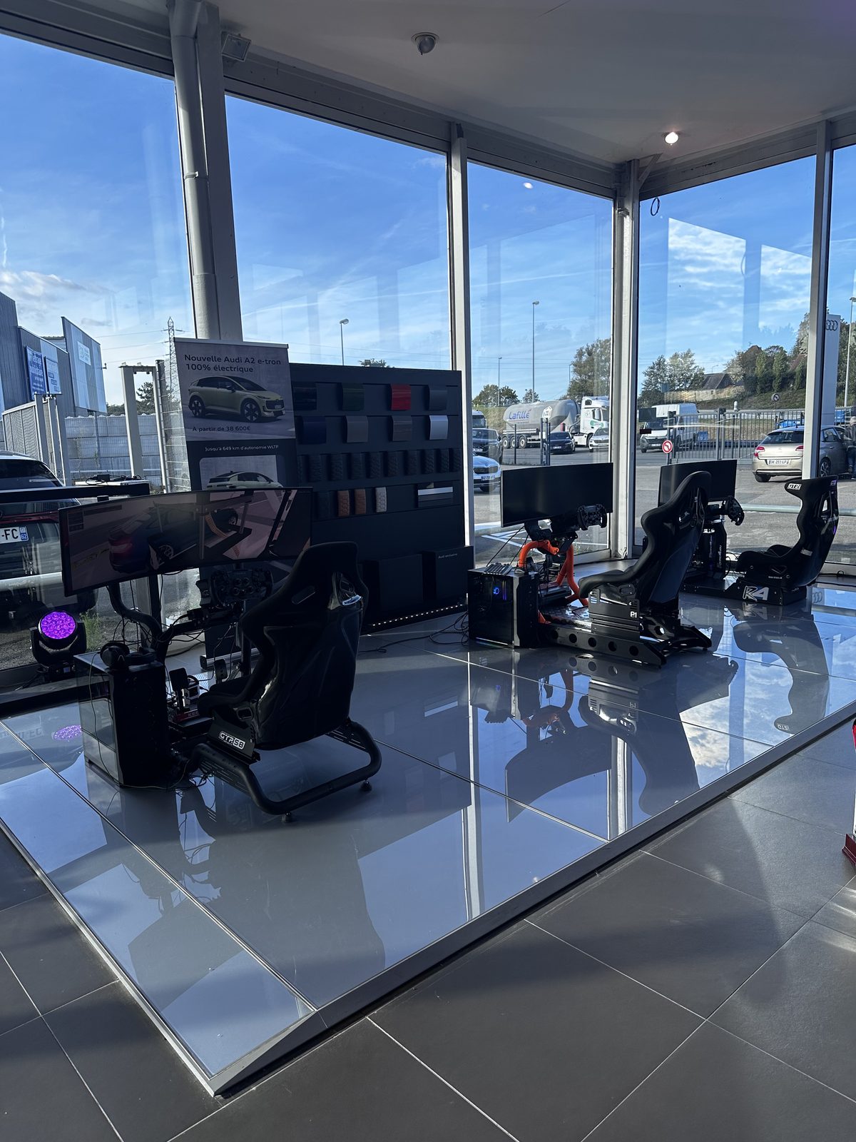 Trois simulateurs SIMBOX installés dans le showroom vitré d'une concession Audi.