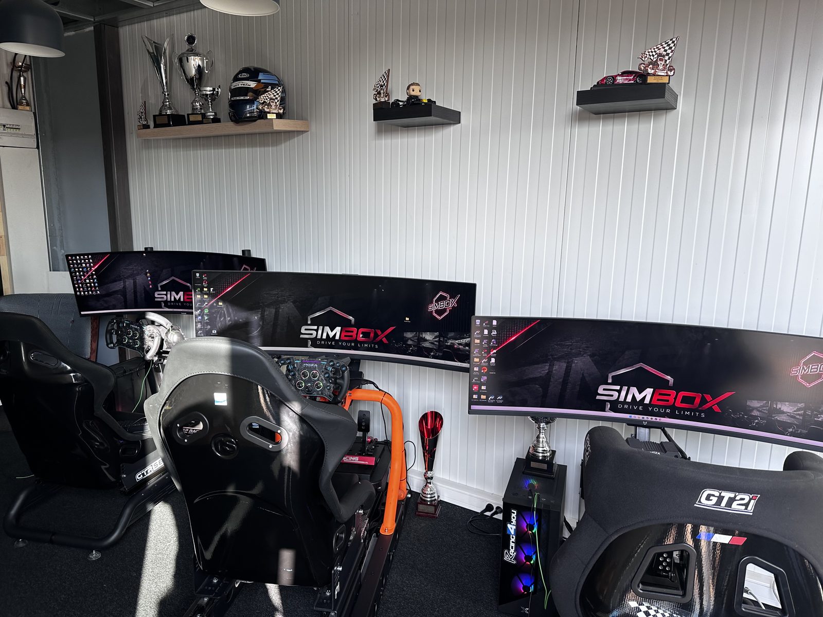 Le plateau SIMBOX avec plusieurs simulateurs alignés et les trophées exposés au mur.